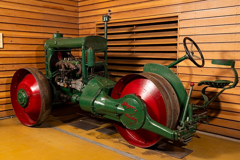 Wallace 'Glasgow' green and red tractor on display, featuring large rear wheels and exposed engine components displayed indoors at the Natural Museum of Rural life.