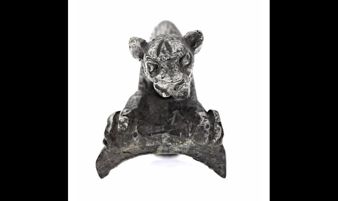 A silver handle in the shape of a leopard.