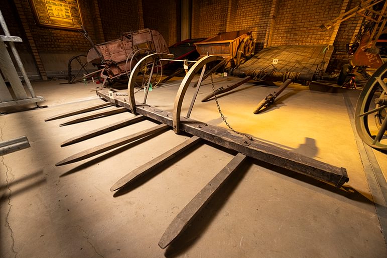 Wooden hay sweep or tumlin tam in front of hay bogey with iron wheels and ropes on the cylinder-shaped pulleys inside at at the National Museum of Rural Life
