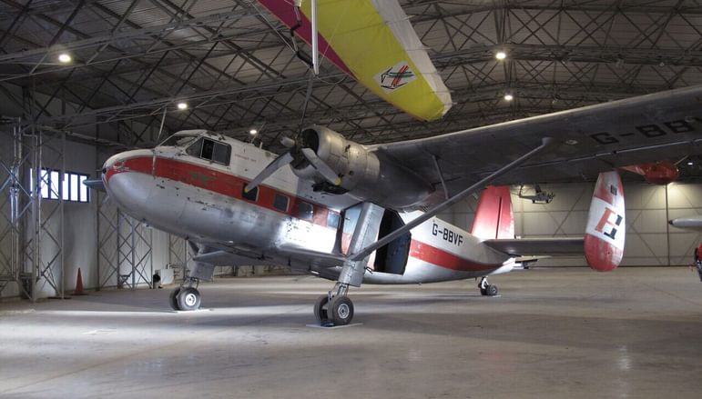 A twin pioneer aircraft in a large aircraft hangar.