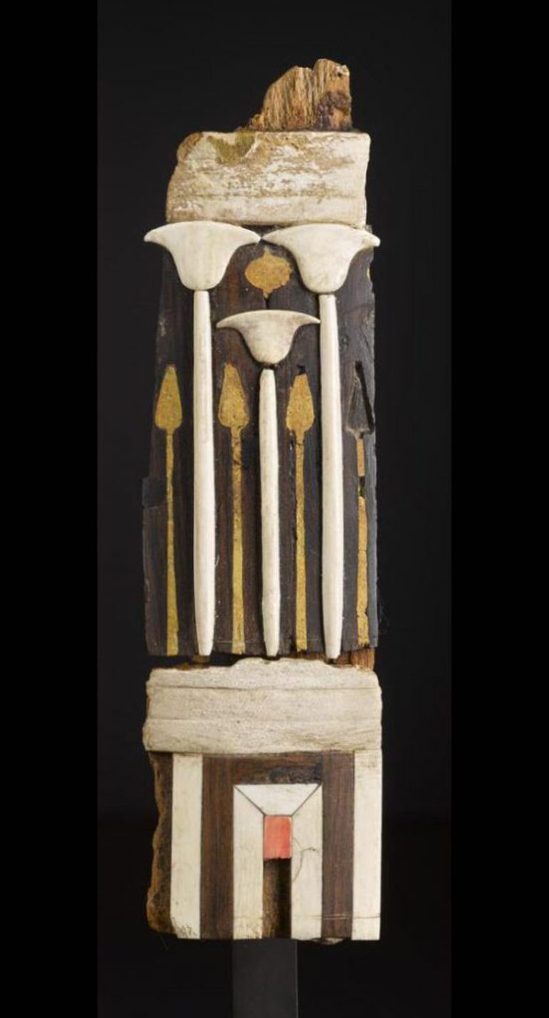 Two tall fragments of decorative wood with gold and ivory details fitted together.