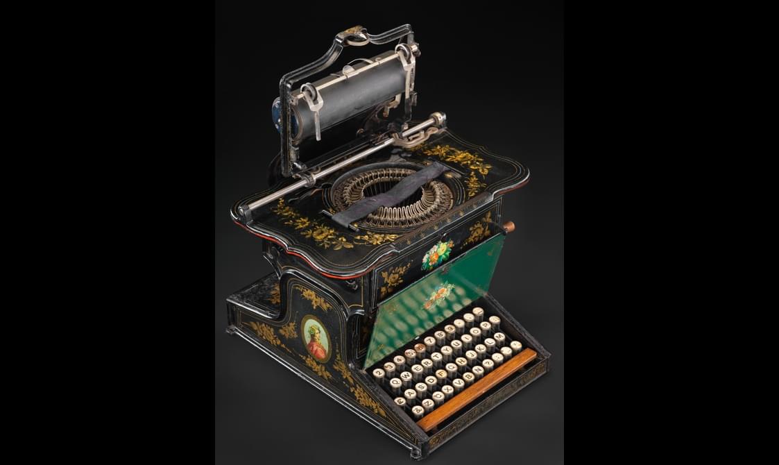 An old typewriter with elaborate paint designs.