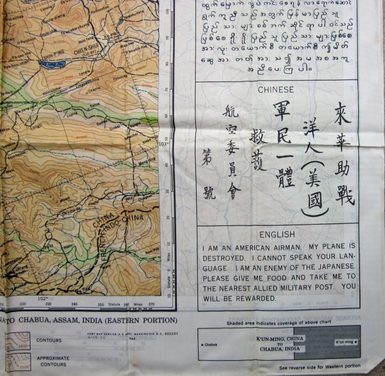 Close up of text on the side of a fabric map. 'I am an American Airman. My plane is destroyed, I cannot speak your language. I am an enemy of the Japanese. Please give me food and take me to the nearest Allied Military Post. You will be rewarded" is translated into Chinese.