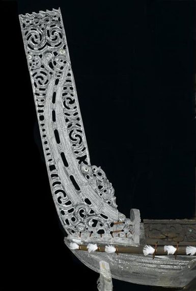 A decorative rectangle made of white acrylic is attached at the end of a wooden canoe.