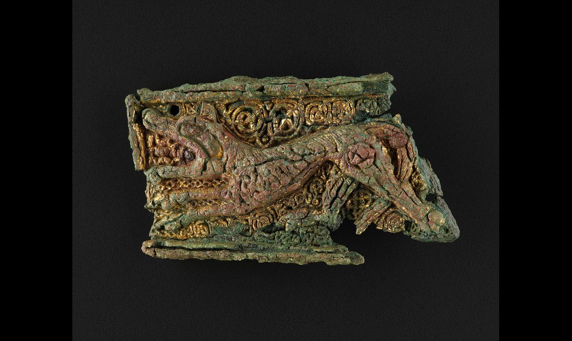 Rectangular gilt-bronze mount depicting a lion, reused as a brooch in the grave of a woman and infant from Westness, Rousay, Orkney, length 66mm,