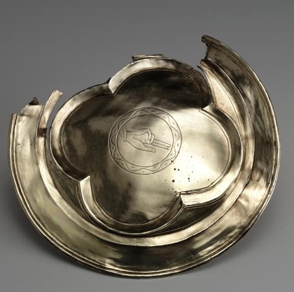 Silver-gilt paten with engraved 'Hand of God' in the centre. Part of the rim is missing.