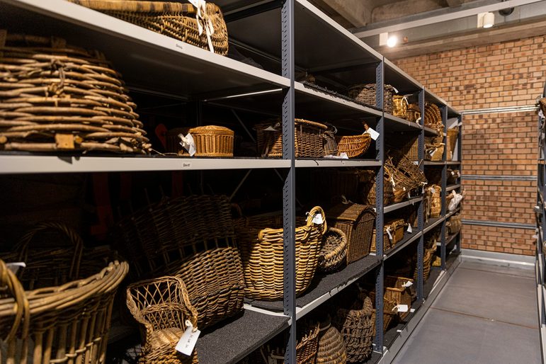 A storage rack in a museum, containing rows of baskets from a museum collection.
