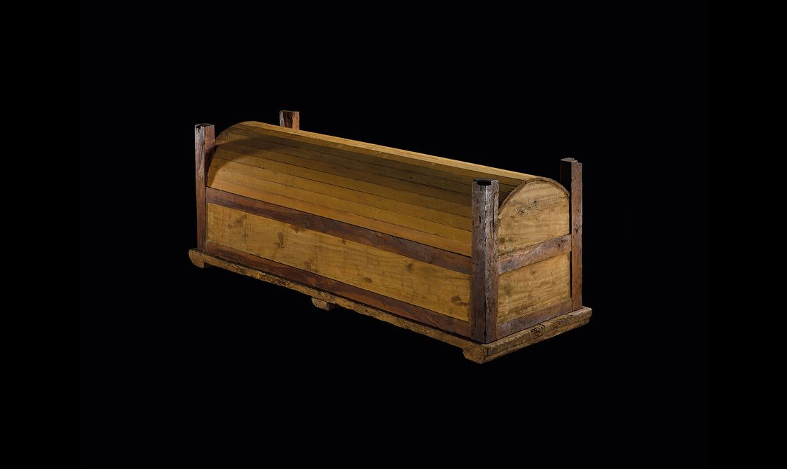 A wooden coffin set against a black background.