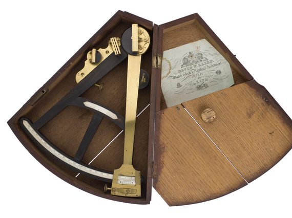 Metal triangular tool in a custom fit wooden box. The lid is open.