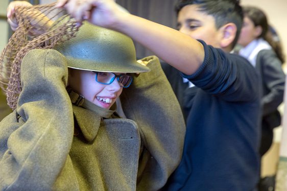 Children dressing up in World War Two uniforms.