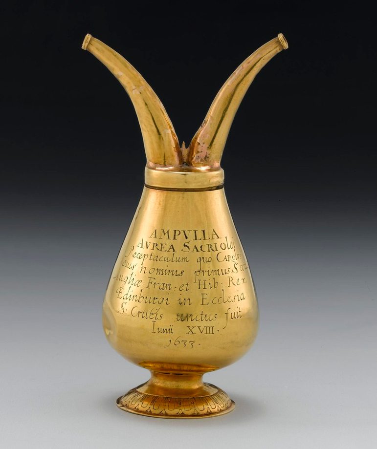 A gold object, in the shape of a goblet with a short handle. There's a lid on top, which also has two prodtruding tubes, which look a bit like antlers.