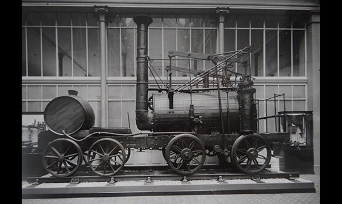A black and white image of a steam engine train on display in a museum.