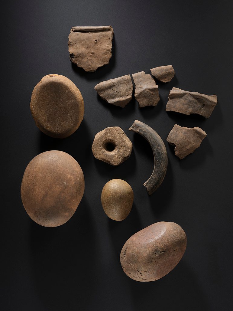 Four rounded stones, some fragments of stone implements, and a quarter of a shale bangle