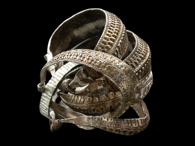 A group of five tarnished silver bangles with elaborately decorated surfaces