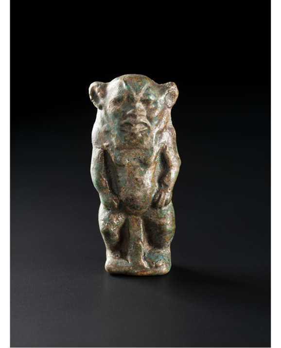 A green figurine of a lion-like animal standing on its hind legs.