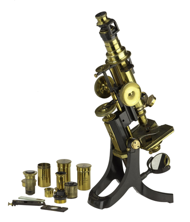 A brass petrological microscope, against a white background.